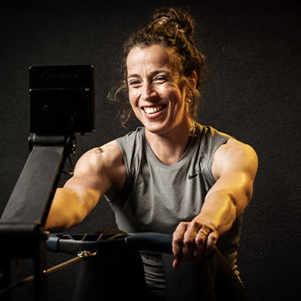 Sportlerin beim Rudern zur Unterstützung ihres Proteinbedarfs für Muskelaufbau und Regeneration.
