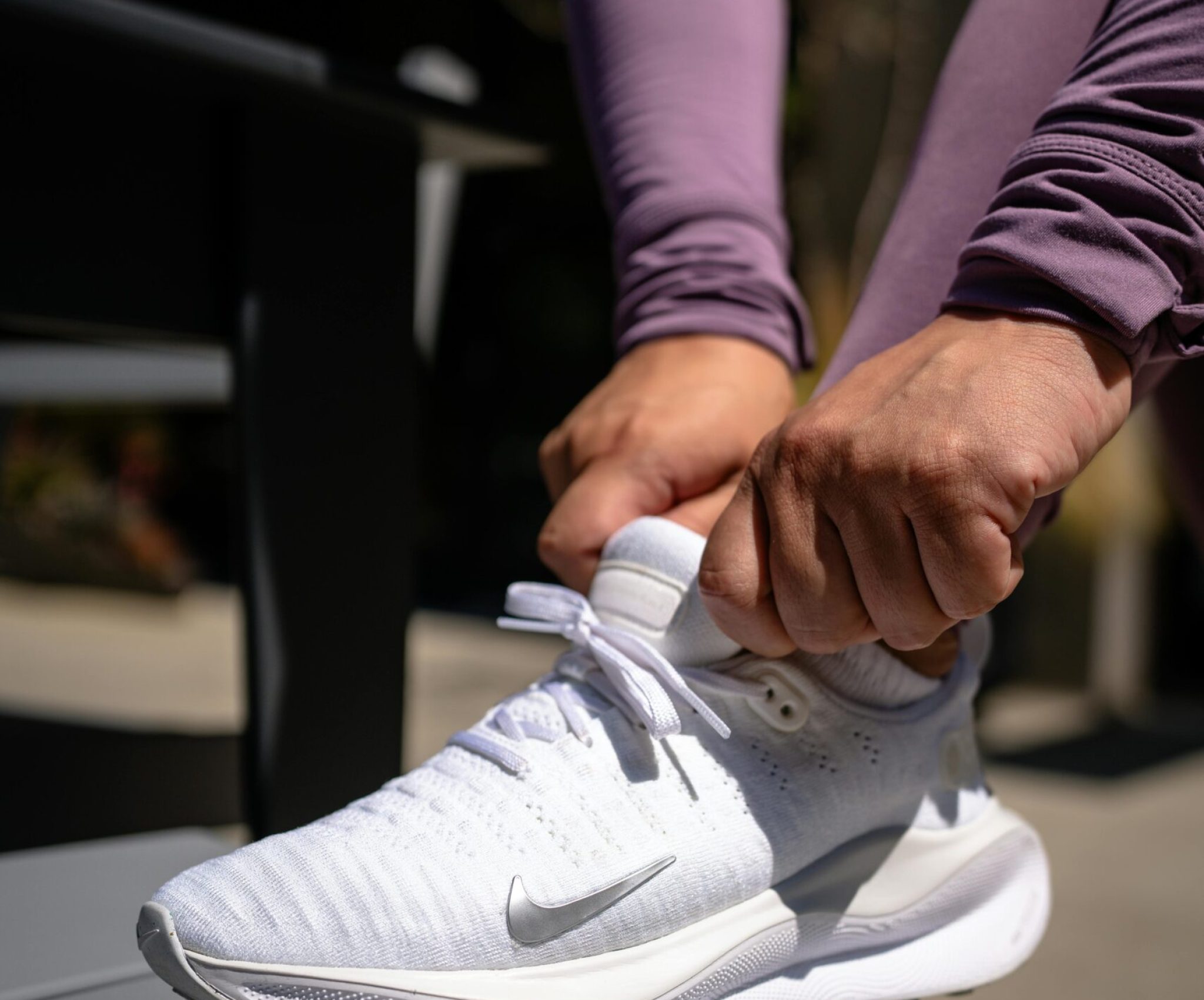 Sportschuhe binden, als Vorbereitung auf ein Training, um Muskelabbau zu stoppen.