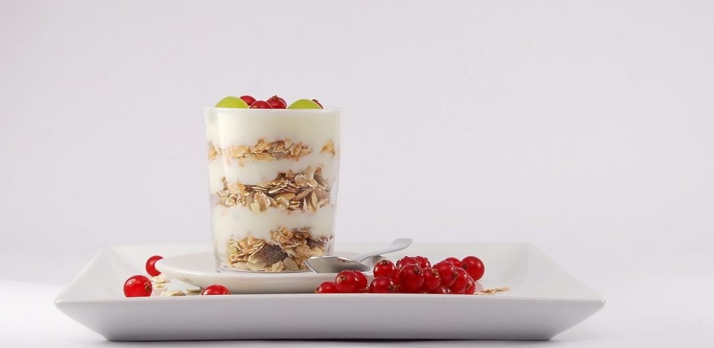 Schichtjoghurt mit Müsli und Beeren: Proteinreiches Frühstück, um den Alterungsprozess ab 40 zu kontrollieren.