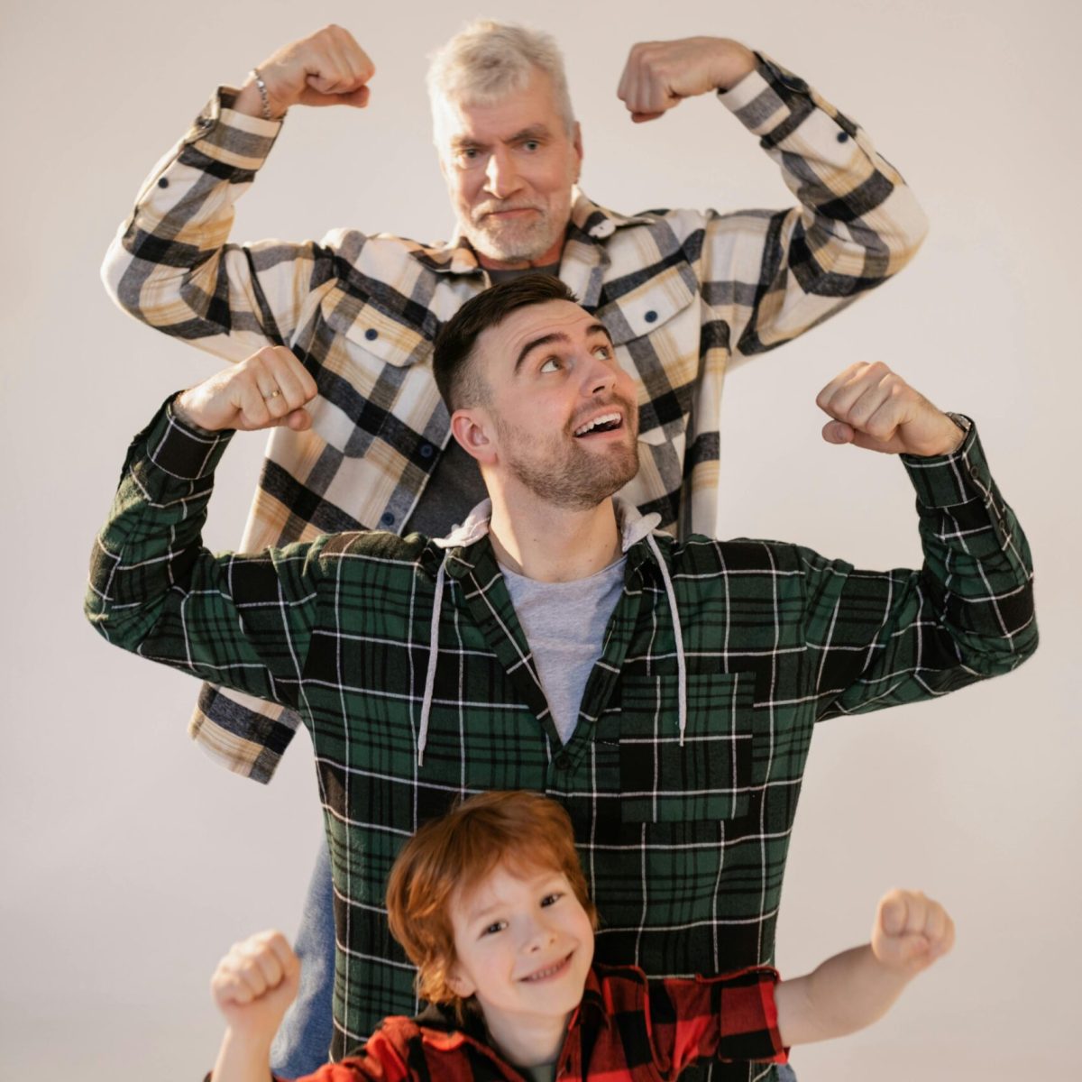 Drei Generationen – Kind, Erwachsener und älterer Mann in kraftvoller Pose, um den Alterungsprozess ab 40 zu kontrollieren und Gesundheit in jedem Alter zu fördern.